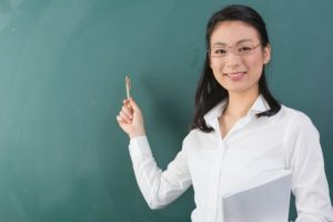 黒板の前の女教師